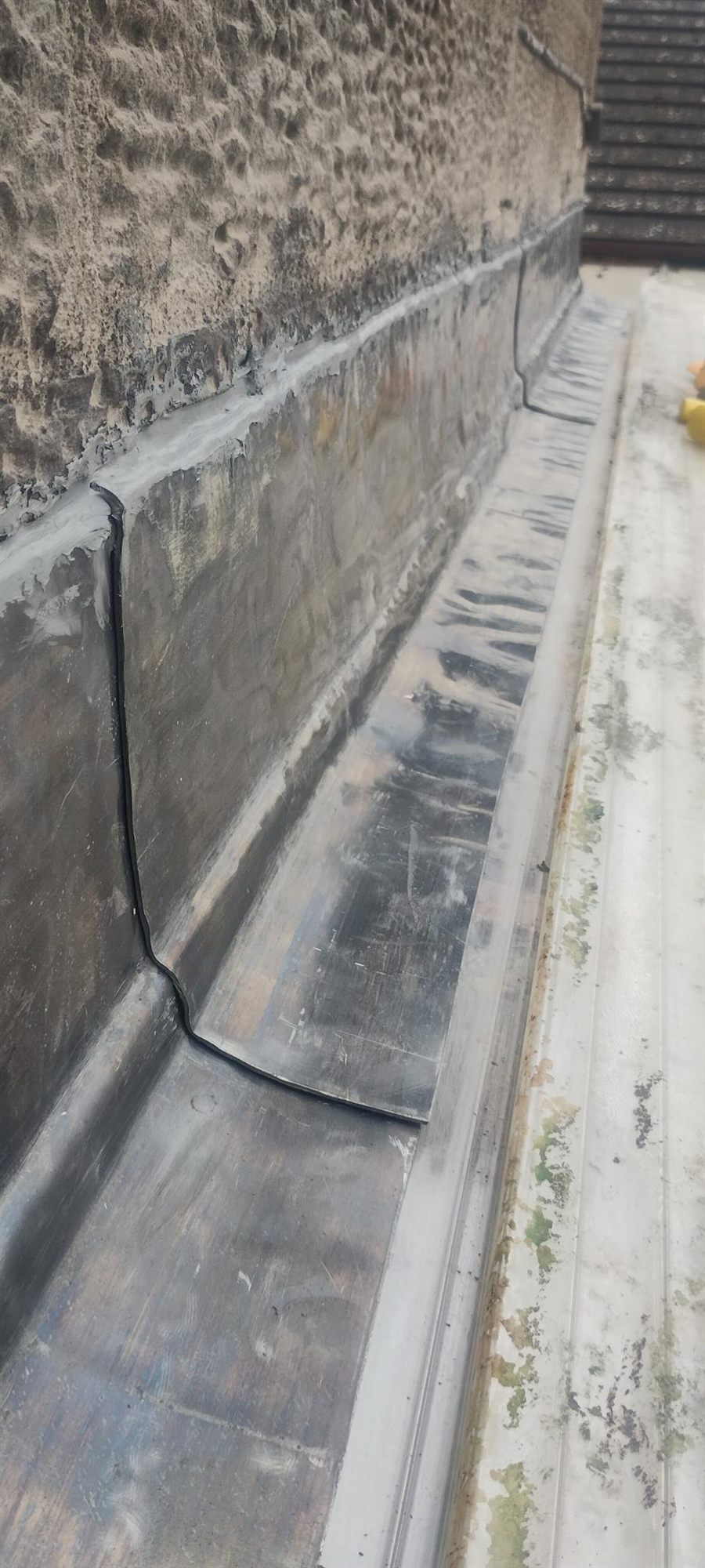 Parapet gutter re-lined — New lead laid into the parapet gutter and welted up against the stonework, so the run drains clean instead of ponding.